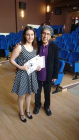 Η Χριστίνα Σαρρή που κρατάει το βραβείο της στο χέρι και στέκεται πλάι σε έναν από τους διοργανωτές της τελετής απονομής