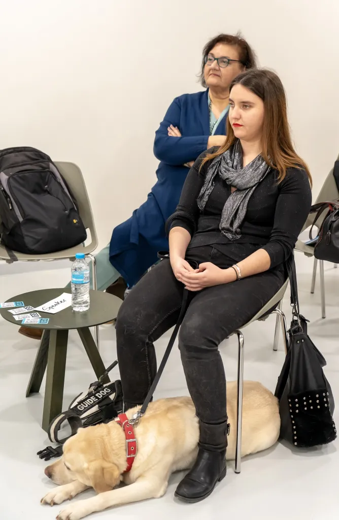 Η Χριστίνα Σαρρή κάθεται σε καρέκλα και η Λούνα είναι κάτω από την καρέκλα της.
