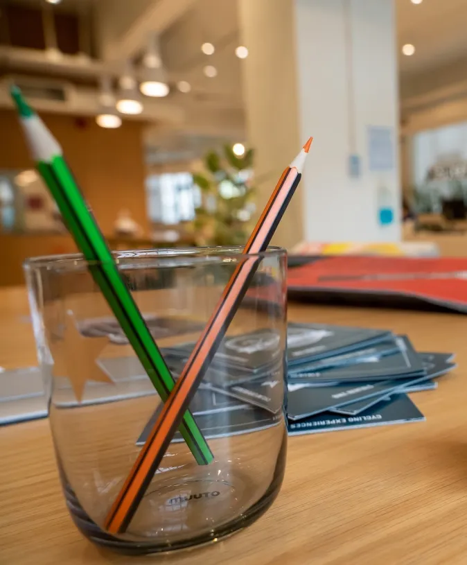 Δύο μολύβια μέσα σε ένα ποτήρι και στο βάθος γενική άποψη του χώρου.
