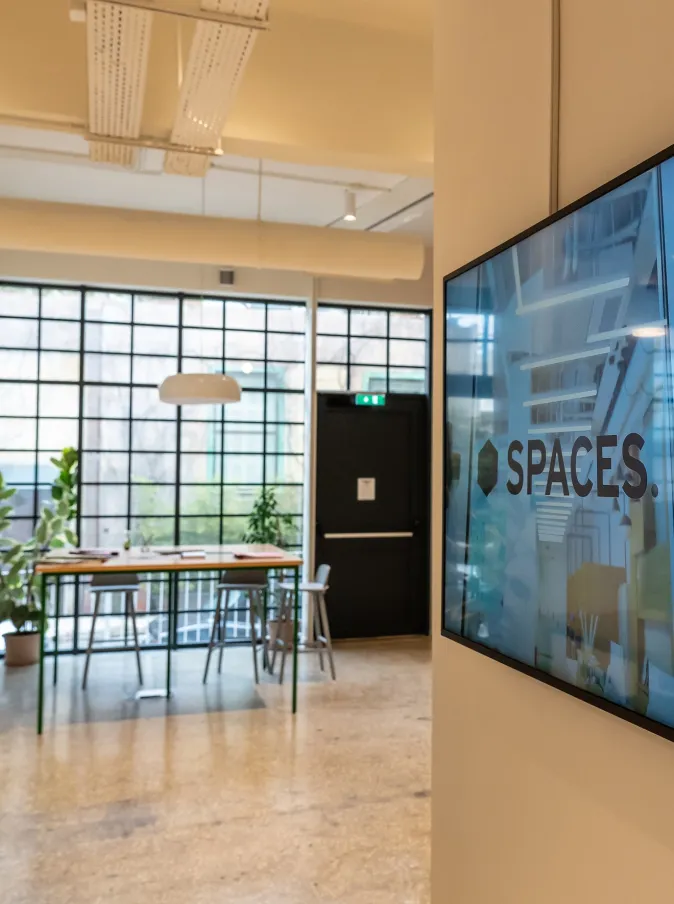 Γενική φωτογραφία του χώρου. Στο βάθος μεγάλο τραπέζι και μεγάλο παράθυρο. Δεξιά οθόνη τηλεόρασης με εικόνα απο το SPACES.
