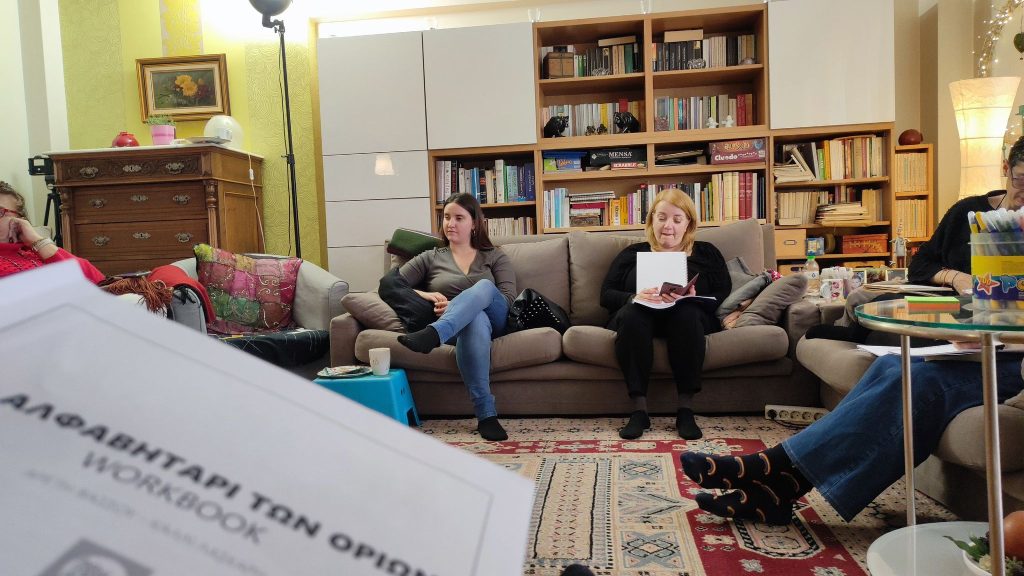 Η Χριστίνα Σαρρή παρακολουθεί με προσοχή. Δίπλα της μία άλλη συμμετέχουσα κρατάει το workbook του σεμιναρίου «Το αλφαβητάρι των ορίων».