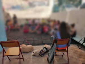 Η Χριστίνα Σαρρή κάθεται σε καρέκλα και αριστερά της είναι τα δύο σκυλιά, ξανθά λαμπραντόρ και μπροστά τα παιδιά